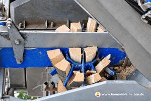 Buchenholz wird mit einer Holzspaltmaschine zu Brennholz verarbeitet